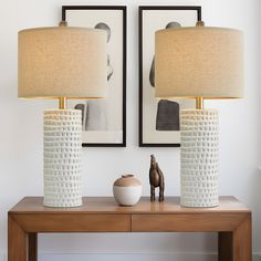 two white vases sitting on top of a wooden table next to a brown horse figurine