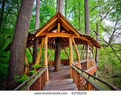 a wooden gazebo in the middle of a forest