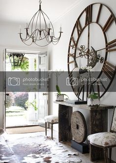 a living room filled with furniture and a large clock on the wall