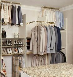 an organized closet with clothes and shoes hanging on the rack, next to a counter top