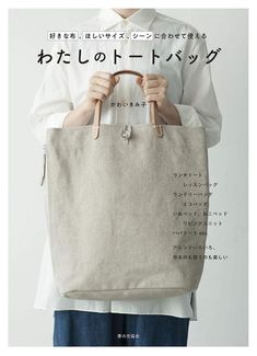 a person holding a bag with japanese writing on the front and bottom half of it