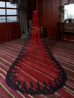 a red and black wedding veil hanging from the ceiling