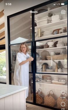 a woman standing in front of a glass door