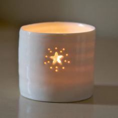 a white candle with gold stars on it