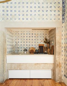 a room with wooden floors and wallpaper on the walls, including a counter top