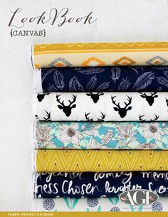 a stack of fabric with different patterns and designs on it, including deer heads in the background