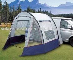 a van parked next to a tent in the grass