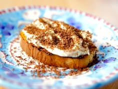 a piece of bread topped with whipped cream and cinnamon sprinkles on a plate