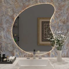 a bathroom sink with a mirror above it and flowers in vases on the counter