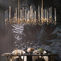 a dining room table with chairs and a chandelier hanging from it's ceiling