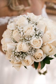 a bridal bouquet with white roses and baby's breath