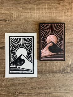 two cards with designs on them sitting next to each other, one has a sun and the other is a bird