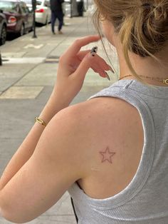 a woman with a star tattoo on her back shoulder