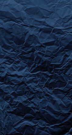 an image of blue wrinkled paper textured with dark colors on the bottom right corner