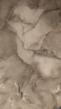 an aerial view of water and sand in the ocean, with waves coming up on it