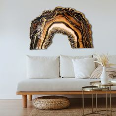 a living room with a white couch and wooden table in front of the painting on the wall