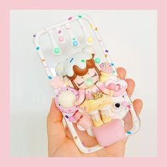 a hand holding a cell phone case with an ice cream sundae doll on it