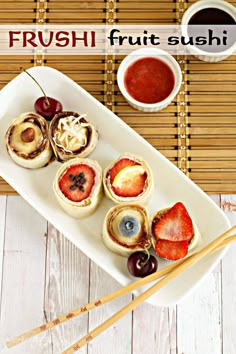 fresh fruit sushi on a white plate with chopsticks and dipping sauce next to it