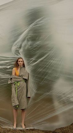 a woman is standing in front of a large plastic sheet with her hands on her hips