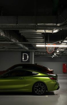 a green sports car parked in a parking garage next to a red sign that says d