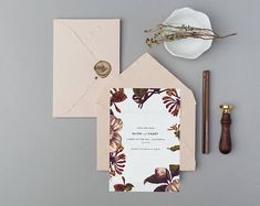 the wedding stationery is laid out on top of an envelope and some other items