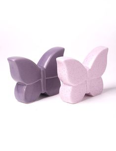 two purple butterfly shaped soaps sitting next to each other