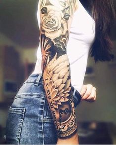 a woman's arm with flowers on it and an owl in the middle,