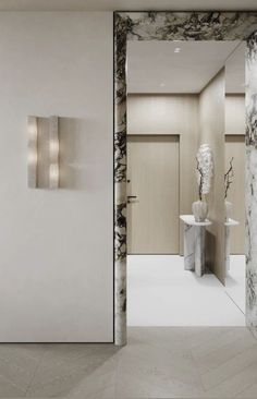 an open door leading to a bathroom with marbled walls and flooring on both sides