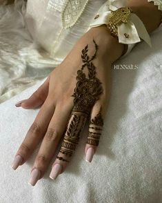 a woman's hand with henna tattoos on it