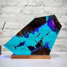 there is a glass sculpture that looks like it has an ocean scene on it and fish in the water