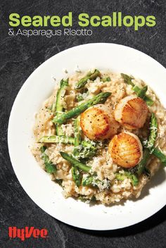 a plate with scallops and asparagus risotto on it is shown