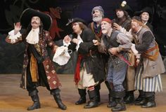 a group of men in pirate costumes standing next to each other on top of a stage