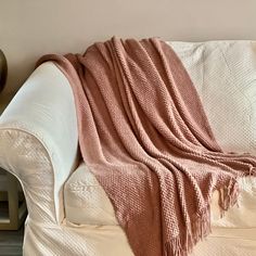 a white couch with a pink blanket on it