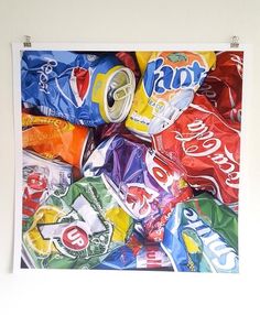 a pile of assorted soda cans on top of a wooden table