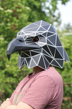 a man wearing a paper mask with an eagle on it's face and one eye open