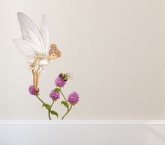 there is a flower with a fairy on it and a bee flying over the flowers