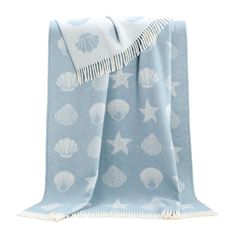 a blue and white blanket with shells on it