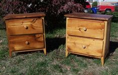 two wooden chests sitting in the grass next to each other