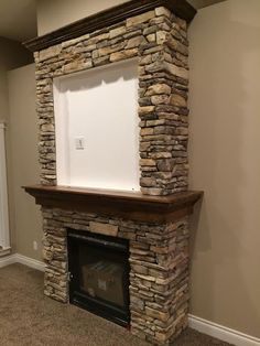 an empty fireplace in a living room with a stone mantle and white board on top