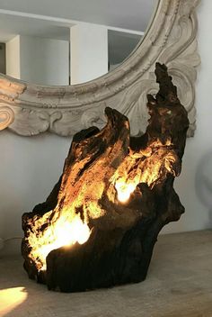 a large piece of drift wood sitting on top of a table next to a mirror