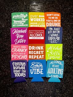 several different colored paper tags with words on them sitting next to each other in front of a glass bottle