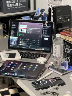 an open laptop computer sitting on top of a desk next to books and other items