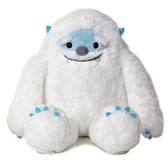 a white stuffed animal with blue eyes and paws