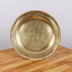 a gold plate sitting on top of a wooden table