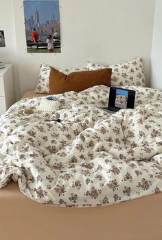 an unmade bed with a laptop on it