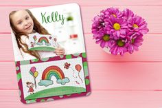 a pink flower next to a photo frame with a rainbow on it and the name kelly