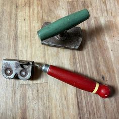 a red and green tool sitting on top of a wooden table