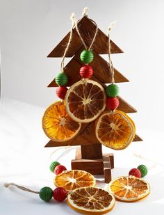 a wooden christmas tree made out of oranges and other fruit is on the table