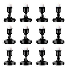 a set of twelve black candle holders with white candles