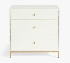 a white dresser with three drawers and gold handles